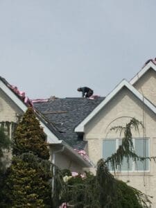 Worker on top of gabled house roof