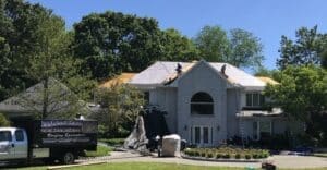 Roofers installing underlayment on large house