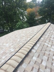 Beige ridge vent and shingle cap on roof