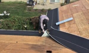 Roofer laying underlayment on residential roof