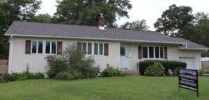 Ranch house with new roof and siding sign