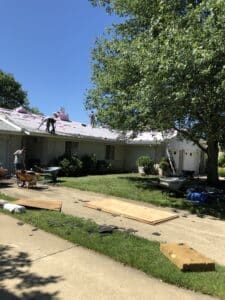 Ranch house roof replacement with materials on driveway