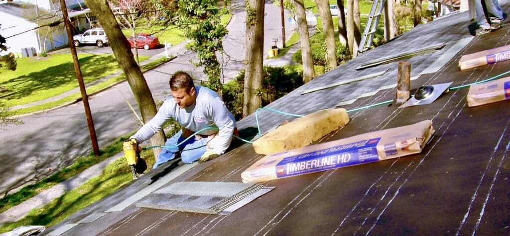 Boss of East Brunswick New Jersey roofing company on roof nailing roofing shingles