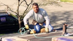 Worker installing shingles on residential roof