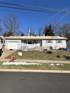 Crew reroofing single-story suburban home