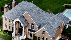 Aerial view of expansive shingle roof and pool