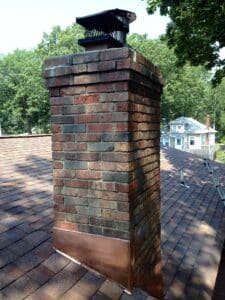 Chimney with copper step flashing and cap