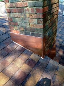 Close-up of copper base flashing around chimney