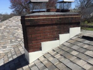 Chimney with stepped brick design on a roof.