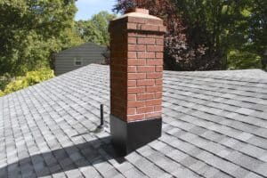 Gray shingles and brick chimney with black flashing